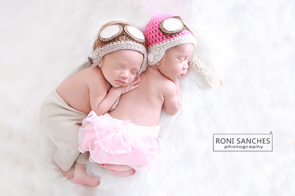 Bebês gêmeos newborn recém nascidos com touca de aviador