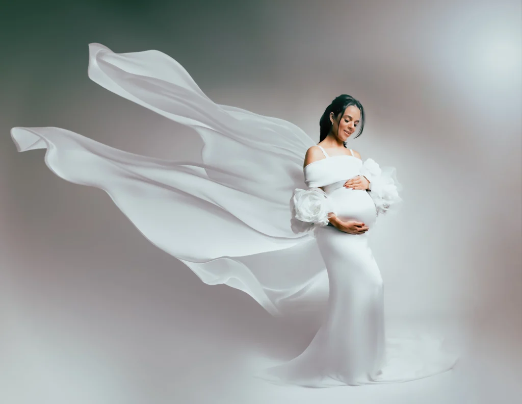 nsaio gestante em SP: gestante usando vestido branco longo com tecido fluido em estúdio de fotógrafo especialista em book gestante e newborn.