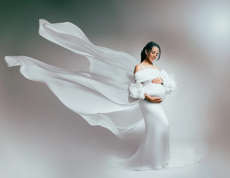 nsaio gestante em SP: gestante usando vestido branco longo com tecido fluido em estúdio de fotógrafo especialista em book gestante e newborn.